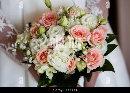 Mariage bouquet de roses fuschia freesia et dans les mains d'une femme méconnaissable Banque D'Images