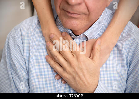 Close-up of young person's hand holding personne âgée la main. Concept Les soins aux personnes âgées Banque D'Images