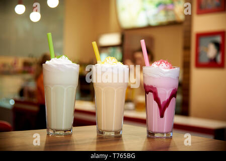 Milk-shakes avec paille sur une table en bois dans un café. Banque D'Images