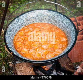 Repas de haricots et de la charcuterie est la cuisson à big metal bouilloire sur feu de bois dans la nature, Close up Banque D'Images