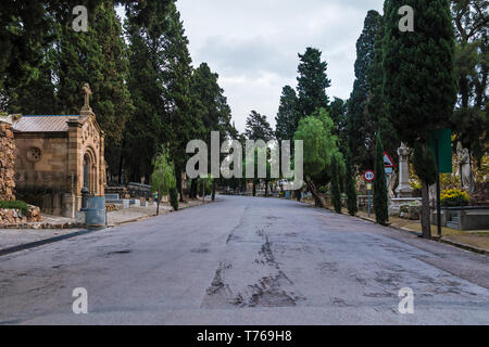 Vue en perspective de la route, tombes et arbres sur le cimetière de Montjuic en image, Barcelone, Catalogne, Espagne Banque D'Images