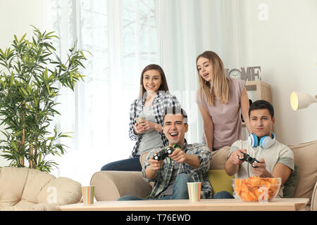 Les jeunes à jouer à des jeux vidéo à la maison Banque D'Images