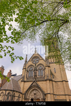 York's St Wilfrid's 19e siècle Église catholique romaine. Il y a des ornements sculptés au-dessus de la porte et un arbre avec un feuillage de printemps est au premier plan. Banque D'Images