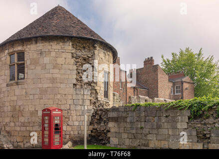 L'ancienne tour ronde situé dans les murs de la ville de New York. Les maisons sont de l'autre côté et il y a un ciel nuageux au-dessus. Banque D'Images