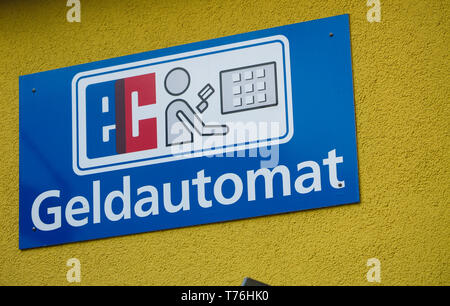 Vue sur panneau bleu isolé sur mur jaune indiquant un distributeur automatique (Allemand lettres «Geldautomat' signifiant un guichet automatique) Banque D'Images