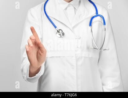 Femme médecin montrant quelque chose sur fond blanc Banque D'Images