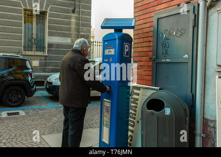 Alba Cuneo, Italie / 03-11-2019 : Vieil homme avec l'aide auditive, obtenir le ticket pour le parking payé en Italie. Banque D'Images