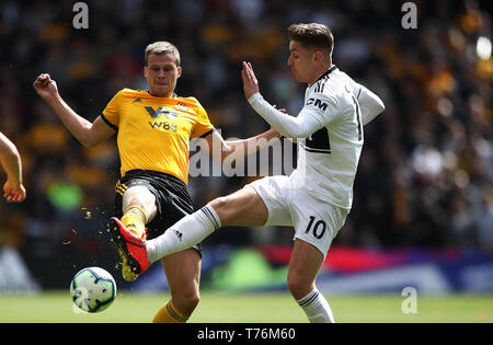 Ryan Bennett des Wolverhampton Wanderers (à gauche) et Fulham's Tom Cairney (à droite) bataille pour la balle au cours de la Premier League match à Molineux, Wolverhampton. Banque D'Images