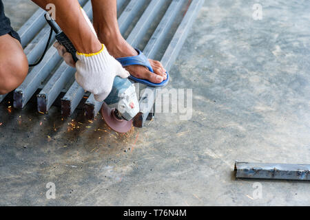 Worker cutting metal avec broyeur et d'étincelles pendant le meulage de l'acier Banque D'Images