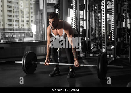 Bodybuilder barbu de l'exercice à la salle de sport se pencher maintenant hâte d'haltères de graves Banque D'Images