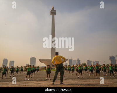 Voir l'investiture d'un grand nombre d'hommes exerçant au Monument National en place Merdeka Jakarta, Indonésie avant la course annuelle. La ville est beh Banque D'Images