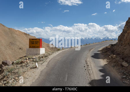 La section de route pavée en haute montagne l'arrondissement courbe sur passer à travers la montagne en Cachemire, Inde sur une journée ensoleillée avec signe rappelant aux peop Banque D'Images