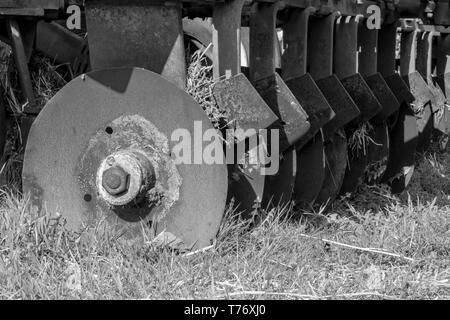 Rangée noire et blanche de carters de cultivateur de herses à disques usés Banque D'Images