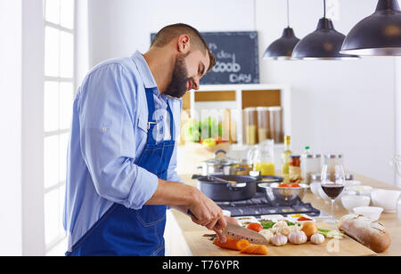 Jeune chef prépare un homme dans la cuisine. Banque D'Images