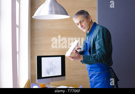 Profession, la menuiserie, la boiserie et les personnes concept - carpenter planche en bois d'essai d'uniformité à l'atelier. Banque D'Images