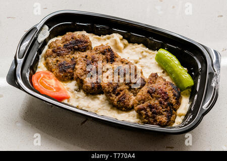 Fast food turc Kofte / Kofta aubergine grillée avec Hunkar Begendi dans la tasse en plastique / Conteneur. (Aubergine Kebab ou Kebap). L'alimentation traditionnelle des viandes. Banque D'Images