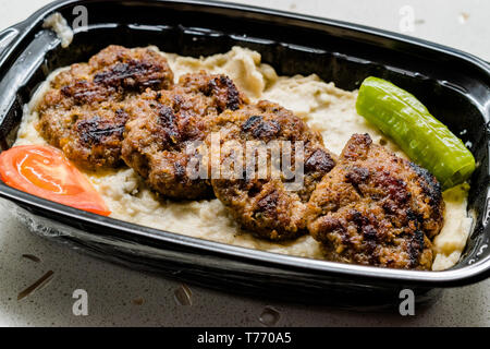 Fast food turc Kofte / Kofta aubergine grillée avec Hunkar Begendi dans la tasse en plastique / Conteneur. (Aubergine Kebab ou Kebap). L'alimentation traditionnelle des viandes. Banque D'Images