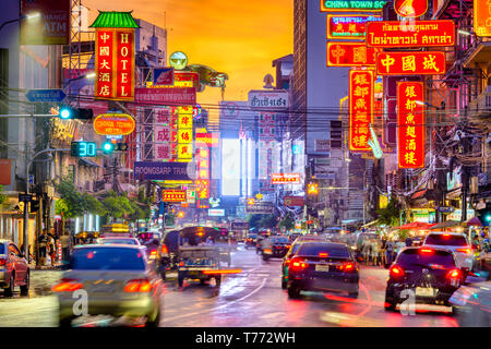 BANGKOK, THAÏLANDE - 27 septembre 2015 : Le trafic sur Yaowarat Road passe sous allumé des signes dans le quartier chinois au crépuscule. Banque D'Images