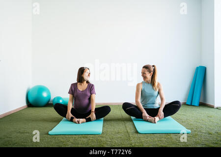 Deux amis de faire du sport dans une salle de sport, l'un d'eux est enceinte. Banque D'Images