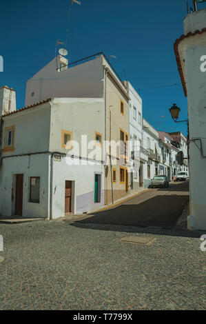 Vieilles maisons en bandes de plâtre fissuré et désert chaussée sur une pente de la rue Campo Maior. Une ville avec des influences médiévale dans l'est du Portugal. Banque D'Images