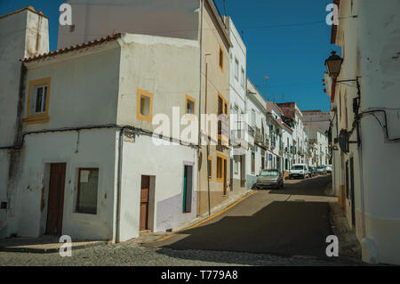 Vieilles maisons en bandes de plâtre fissuré et désert chaussée sur une pente de la rue Campo Maior. Une ville avec des influences médiévale dans l'est du Portugal. Banque D'Images