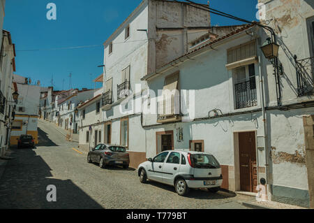 Vieilles maisons en bandes de plâtre fissuré et désert chaussée sur une pente de la rue Campo Maior. Une ville avec des influences médiévale dans l'est du Portugal. Banque D'Images