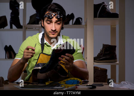 Les jeunes dans la nuit de l'atelier de cordonnier Banque D'Images