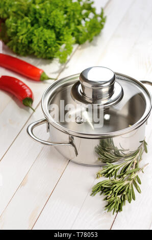 Casserole sur une table en bois avec des condiments et assaisonnements Banque D'Images