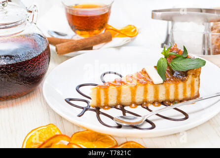 Un morceau de gâteau servi sur une table avec du thé et de la confiture. Banque D'Images