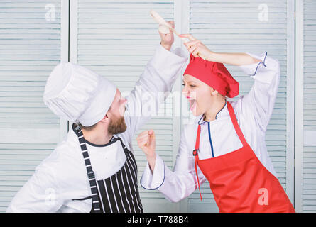Cuisine ultime défi. Bataille de deux chefs culinaires. Couple en compétition en arts culinaires Cuisine règles. Qui mieux cuisiner. Bataille culinaire concept. Femme et homme barbu show culinaire concurrents. Banque D'Images