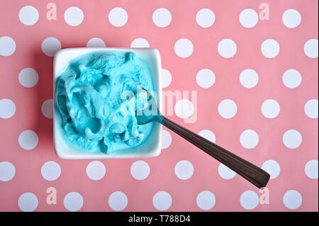 Blue Ice cream dans un bol blanc sur un fond bleu à pois rose Banque D'Images
