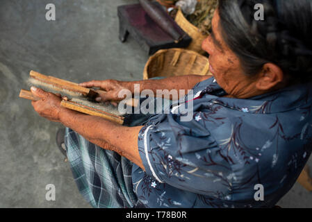 Woman combing zapotèque la laine brute à l'aide d'une carde de préparer la fibre de laine pour la filature (à faire de la laine). Teotitlan del Valle, Oaxaca, Mexique. Apr 2019 Banque D'Images