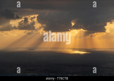 Les rayons du soleil de passer par les nuages dans la mer et un porte-conteneurs Banque D'Images