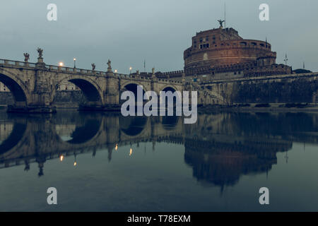 Tibre avec l'Aurelius pont sur eaux avec Château Sant Angelo au crépuscule. Reflets de la pont de pierre dans l'eau avec l'allumé buildi Banque D'Images
