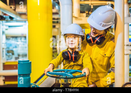 Jeune homme et un petit garçon sont tous deux dans un uniforme de travail jaune, verres, et le casque dans un environnement industriel, plate-forme d'huile ou de gaz liquéfié plant Banque D'Images