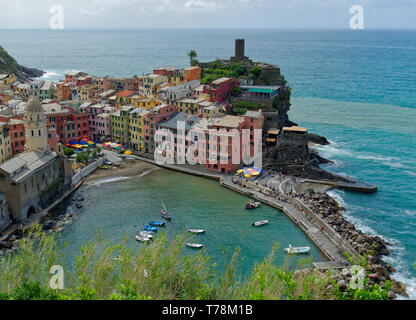 Vue sur les couleurs vibrantes de Vernazza et son port depuis le sentier des Cinque Terre par un beau jour avec un ciel bleu clair Banque D'Images