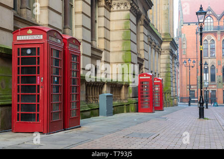 Birmingham, West Midlands / UK - 24 Février 2019 : Eden Place, quatre rouges Giles Gilbert Scott téléphone stand boîtes à côté le bâtiment du Conseil. Banque D'Images