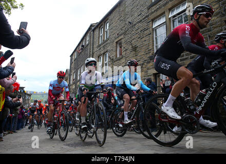 Le peloton principal INEOS équipe y compris chef Chris Lawless comme ils l'escaladent une colline à Haworth aux côtés de l'équipe de Dimension Data Mark Cavendish lors de l'étape 4 du Tour de Yorkshire. Banque D'Images