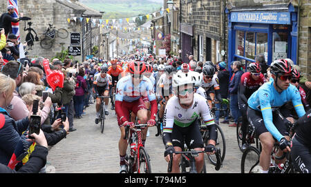 Le peloton principal INEOS équipe y compris chef Chris Lawless comme ils l'escaladent une colline à Haworth aux côtés de l'équipe de Dimension Data Mark Cavendish lors de l'étape 4 du Tour de Yorkshire. Banque D'Images