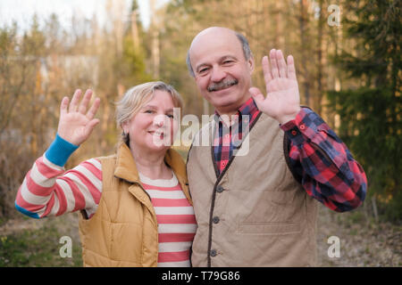 Parents, disant au revoir à leurs enfants en agitant les mains. Banque D'Images