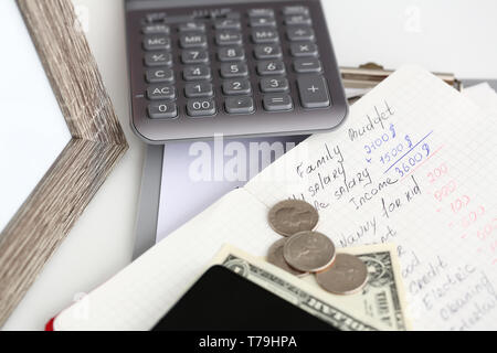 Statistiques financières de la famille écrit sur le bloc-notes page couché sur le tableau Banque D'Images