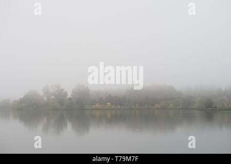 Recherche à travers le lac Dow vers l'Arboretum sur un matin d'automne brumeux, Ottawa, Ontario, Canada. Banque D'Images