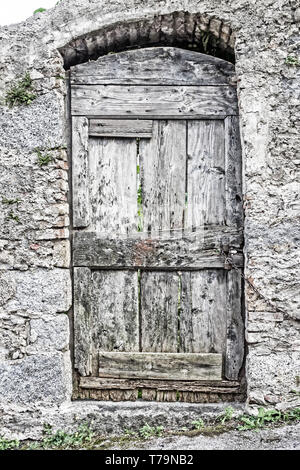 Vieille porte en bois dans un mur en pierre Banque D'Images