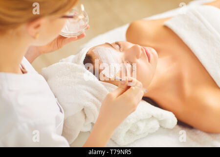 Un cosmetologist applique un masque d'une femme. Banque D'Images