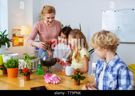 Plant Science leçon. Professeur aux cheveux blonds et ses élèves et intelligente ayant plante étonnante Leçon de science Banque D'Images