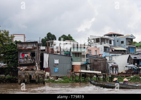 Vue sur quelques maisons à côté de la rivière dans un quartier pauvre du Delta du Mekong, Vietnam Banque D'Images