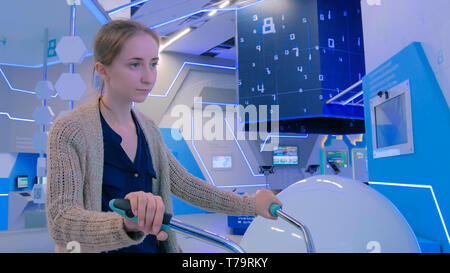 Jeune femme à l'aide d'interactive location machine simulateur Banque D'Images