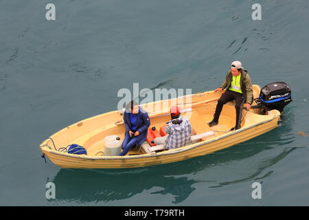 Trois sections locales de règlement dans le sud du Groenland Aappilattoq croisière salue les passagers de leur bateau à moteur. Banque D'Images