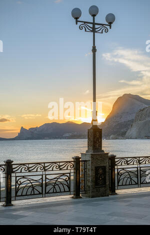 Vue panoramique sur le coucher du soleil au-dessus des montagnes de l'emplacement du nouveau monde de remblai dans Sudak ville, la Crimée, la Russie. Banque D'Images
