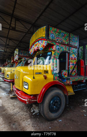 Libre d'une rangée de cabines peintes à la main en couleurs de transport touristique stationné dans un garage de l'entreprise pour la nuit avec chien reposant sous Banque D'Images